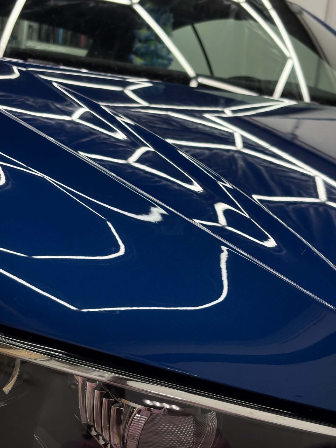 Blauer Fahrzeuglack mit starkem Glanz und klaren Lichtreflexionen